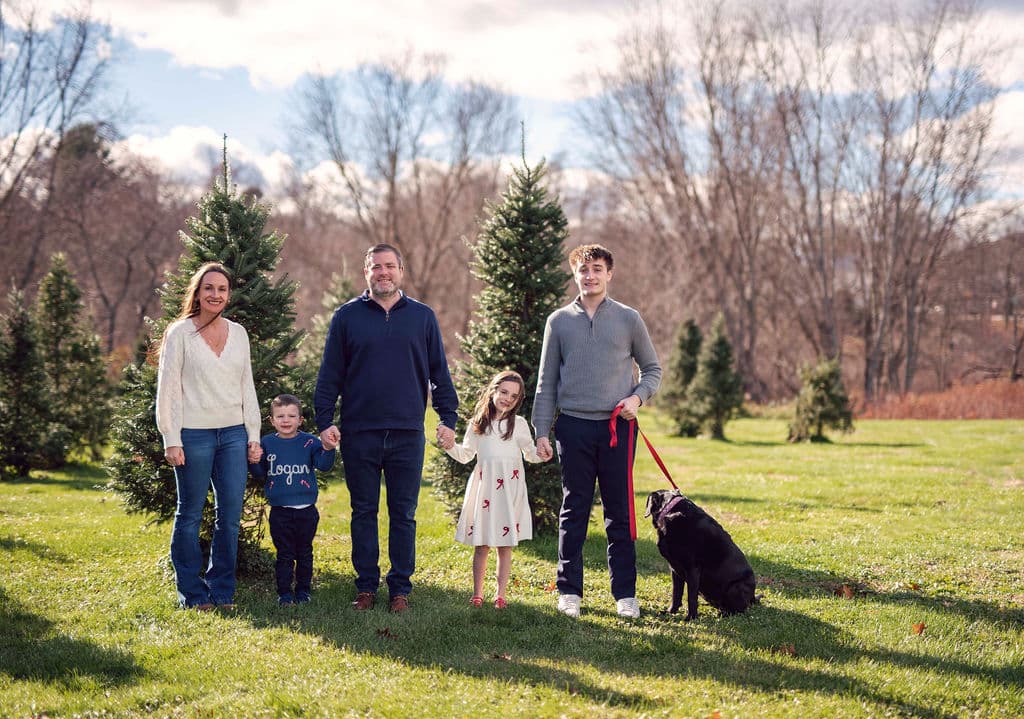 Family with their dog at a Christmas tree farm mini session