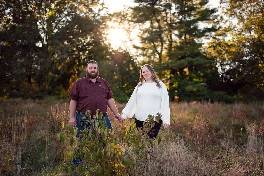 Couple standing in a golden-hour meadow