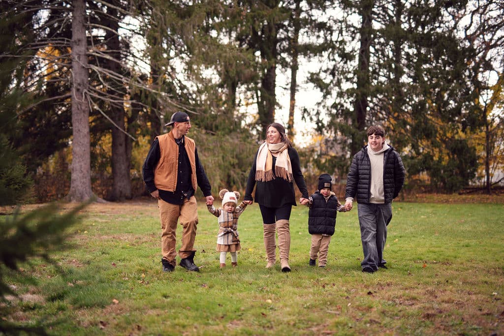 Young family walking together at a fall farm mini session