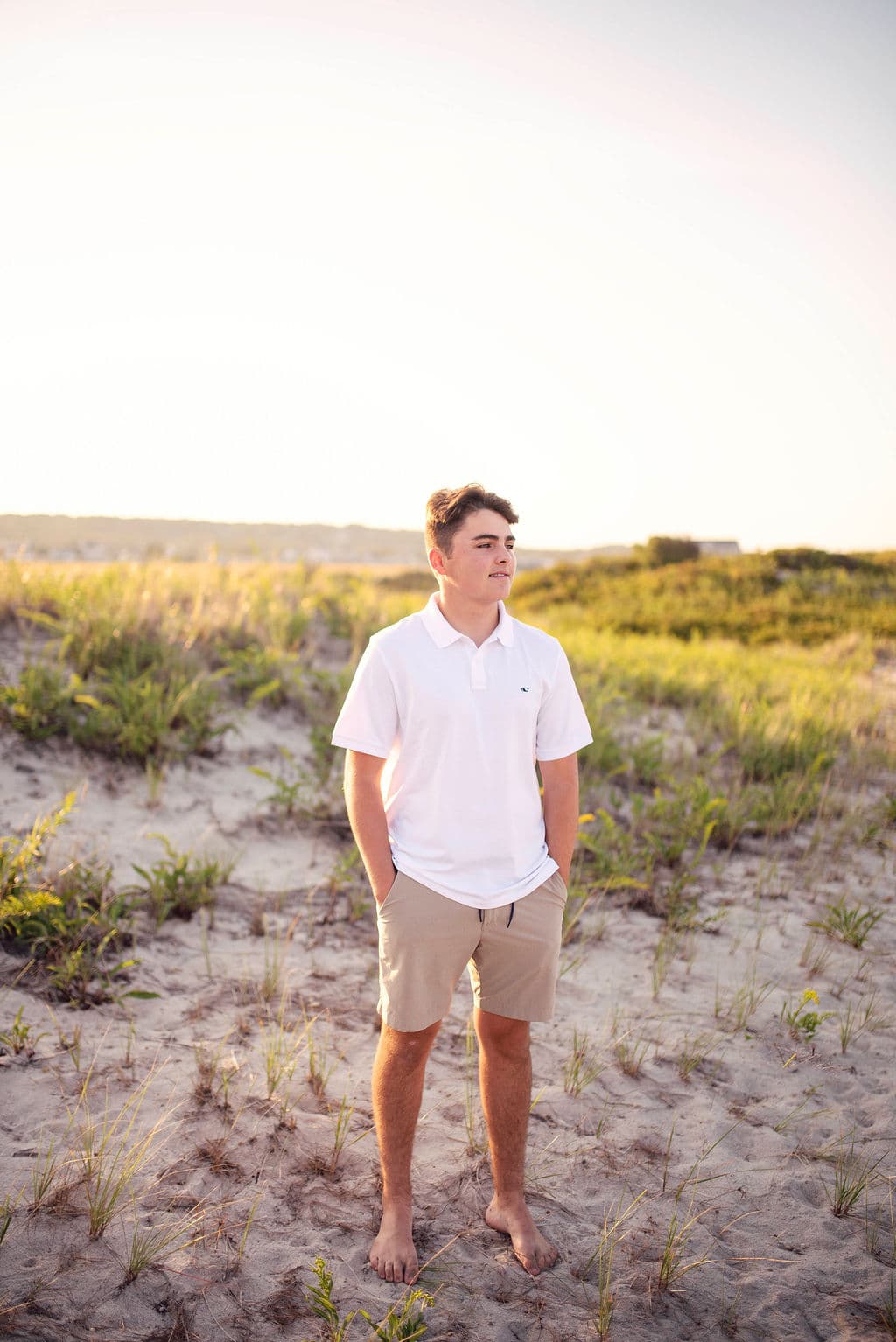 Senior guy standing in dune grass on a summer evening
