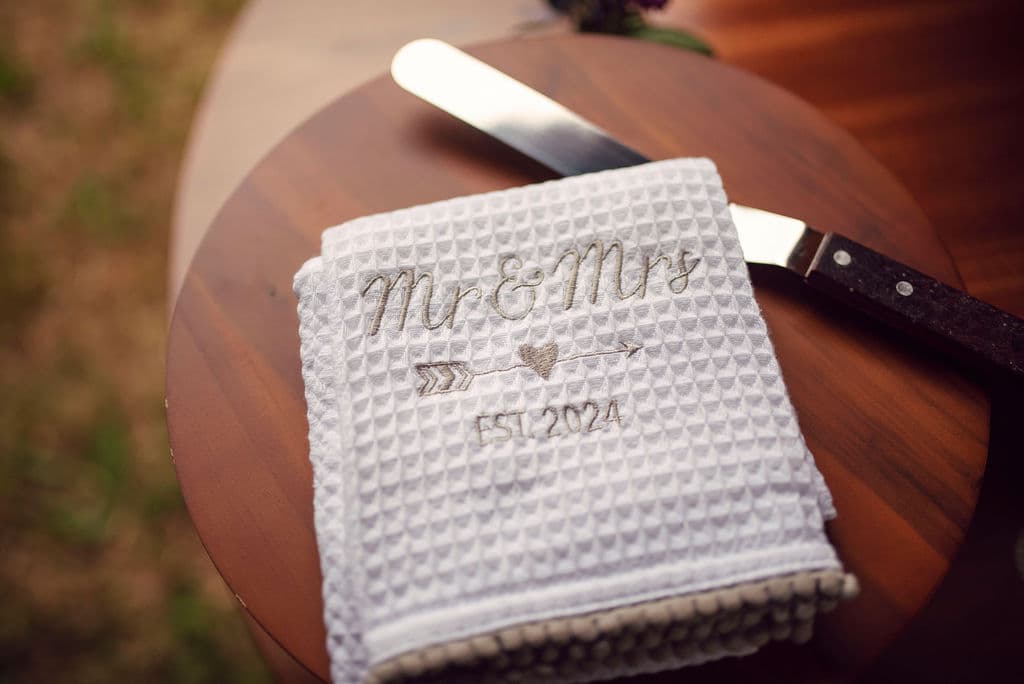 Embroidered Mr. and Mrs. towel detail on a wedding cake board